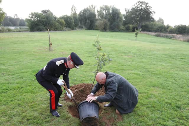 James Saunders Watson and Oliver Wicksteed add compost to the base of the oak sapling