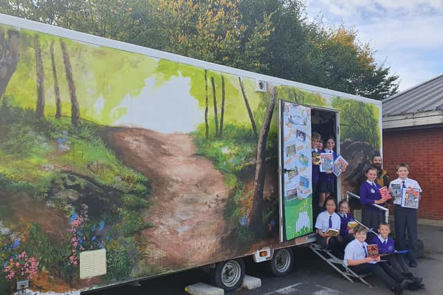 Michael Piper with students at their new forest-themed library.