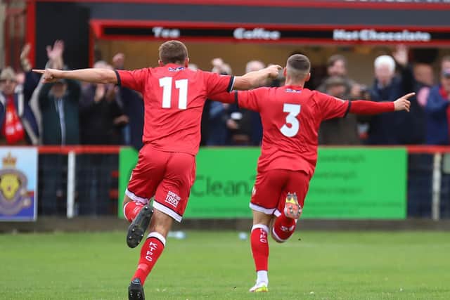 Alex Brown heads off to celebrate after he put Kettering in front