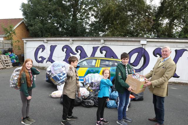 John Nowell from Helipads for Hospitals accepts the cans from the Glendon District Scout group members