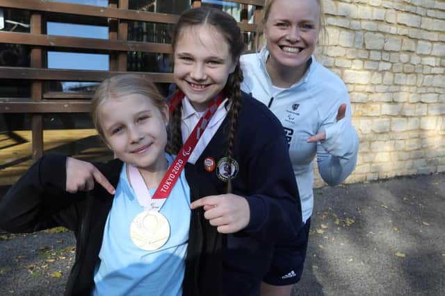 Ten-year-olds Ottilie and Olivia with Laura and her medal