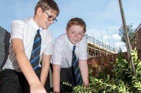Pupils Dylan and Oliver helping to plant in the eco-friendly showhome garden at Davidsons Homes Sanders Fields development