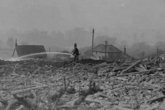 A fireman stands among the shattered remains of Deenethorpe damping down one of many fires.