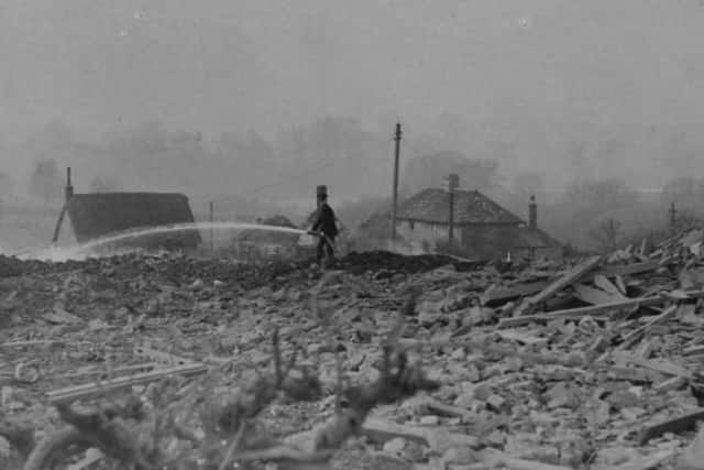A fireman stands among the shattered remains of Deenethorpe damping down one of many fires.