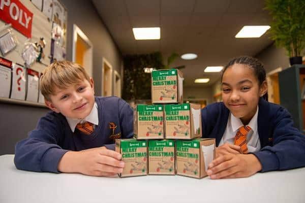 Two pupils at Hayfield Cross CofE Primary School with the Christmas tree kits donated by David Wilson Homes