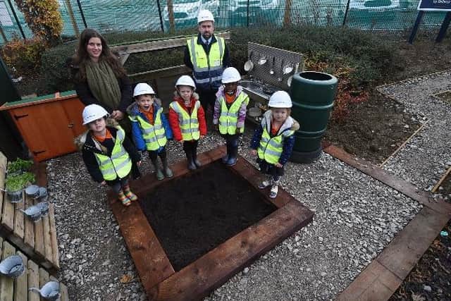 Bellway site manager Steve Beck and reception class teacher Kelly Rose with pupils at Hayfield Cross Church of England School’s new mud kitchen