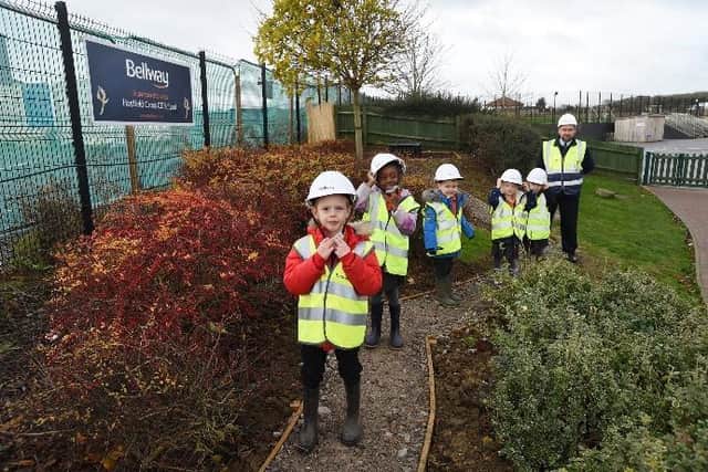 Bellway site manager Steve Beck and reception class teacher Kelly Rose with pupils at Hayfield Cross Church of England School