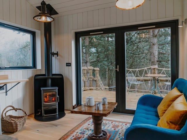 Cosy up in front of the fire in the living room while looking out to the forest.
