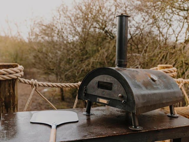 The cosy cabin also comes with a wood-fired pizza oven.