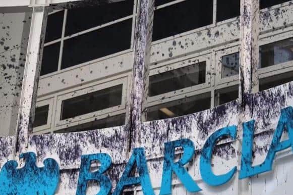 Protestors sprayed ink — representing oil — over the Barclays sign inside the Bracksmills building