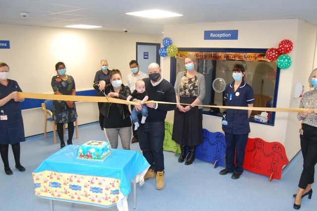 The new clinic’s first patient six-month-old Freddie Gibson and his mum, Jade Jones, and dad, Jason Gibson, cut the ribbon to open the newly refurbished area
