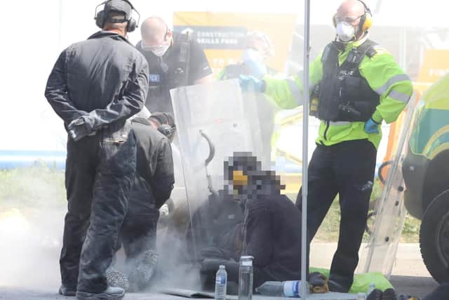 Protesters had sealed their arms into concrete-filled oil drums