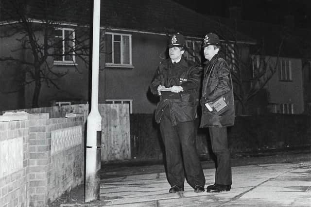 Two police officers stand outside Stein's house in the days before Collette's body was discovered there.