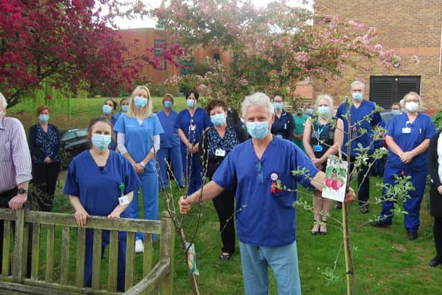 Friends and colleagues say a fond farewell to Julian O’Neill who has just
completed 27 years as KGH’s sole consultant orthodontist. He is pictured with two
apple trees – part of a package of gifts from colleagues.