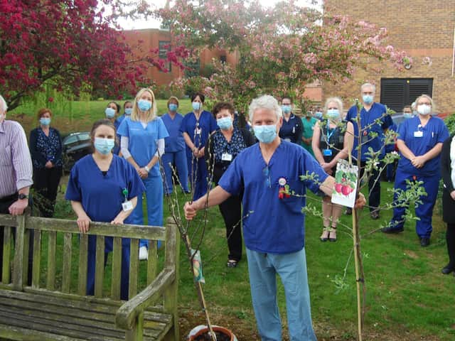 Friends and colleagues say a fond farewell to Julian O’Neill who has just
completed 27 years as KGH’s sole consultant orthodontist. He is pictured with two
apple trees – part of a package of gifts from colleagues.