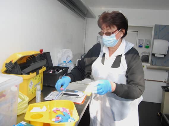 Healthcare Assistant Kate Varnfield preparing tests inside the fast food trailer
headquarters.