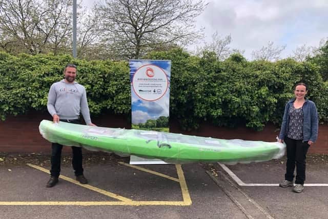 Nick receives his kayak from Corinne Muir