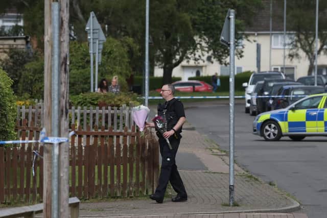 A police officer moving flowers.