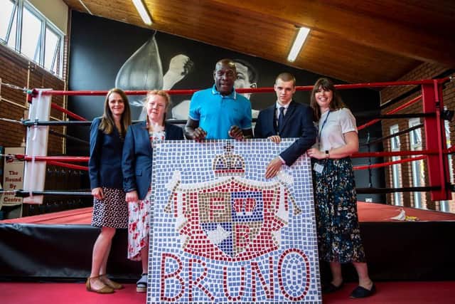Frank Bruno with (L-R) Isebrook School teacher Jenna Priest, pupil Summer Brown, pupil Michael Guy and teacher Jenny Lane and the mosaic at The Round by Round Centre in Northampton