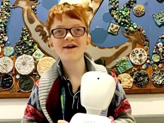 Alexanda Harvey, 13, with his AV1 robot.