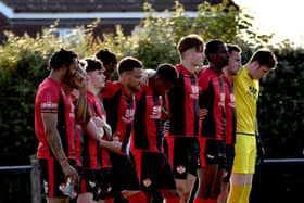 The Kettering Town players observed a minute's silence in memory of former striker and assistant-manager Ernie Moss ahead of last night's friendly at Cogenhoe United. Pictures courtesy of Poppies Media