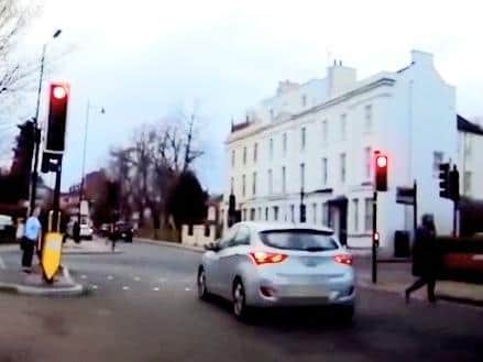 Pedestrians scurry out of the way as a car shoots through a red light outside NGH