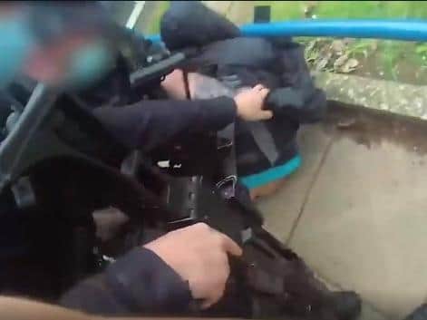 Police wrestle Thanki to the floor after tricking him into taking his hand off the 'detonator'