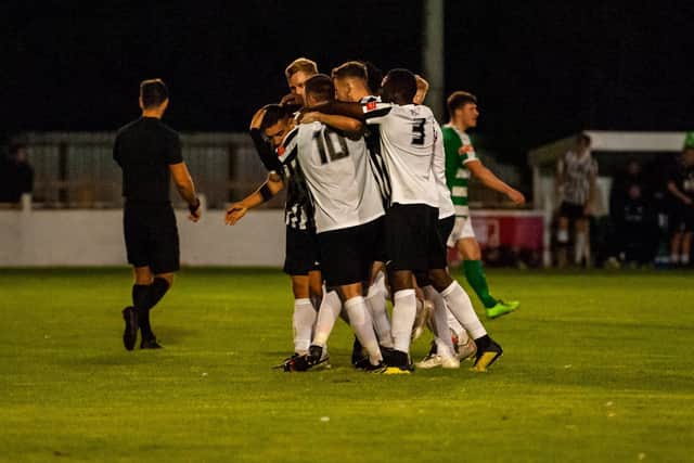Jordan O'Brien is mobbed by his team-mates after his penalty put Corby 3-2 up during extra-time in their FA Cup replay at Soham Town Rangers. Picture by Jim Darrah