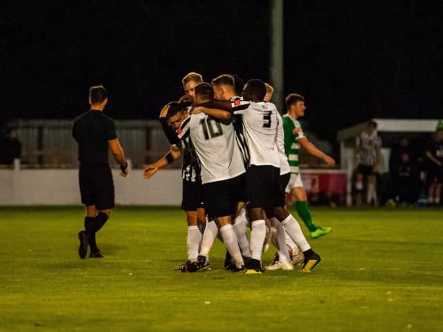 Jordan O'Brien is mobbed by his team-mates after his penalty put Corby 3-2 up during extra-time in their FA Cup replay at Soham Town Rangers. Picture by Jim Darrah