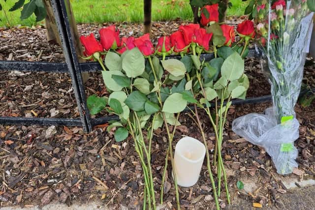 A dozen red roses have been left at the scene