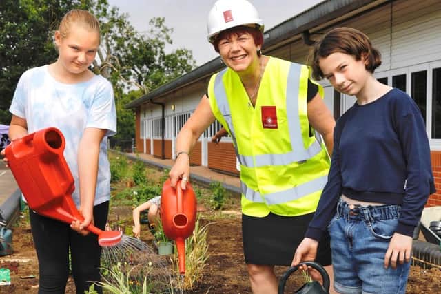Pupils Joycie Harper (left) and Bebe Hunt with Linda Stevens from Davidsons Homes watering some of the plants on the sensory garden.