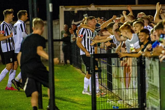 Elliot Sandy celebrates with the Corby Town fans after his 50th goal for the club secured a 1-0 win over Soham Town Rangers at Steel Park. Pictures by Jim Darrah