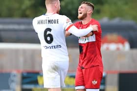 Kettering Town captain Connor Kennedy shares a joke with AFC Fylde skipper Alex Whitmore at the final whistle after the two team drew 1-1 at Latimer Park last weekend. Picture by Peter Short