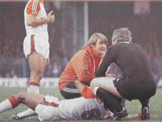 John having a chat with the referee whilst treating Brian Stein