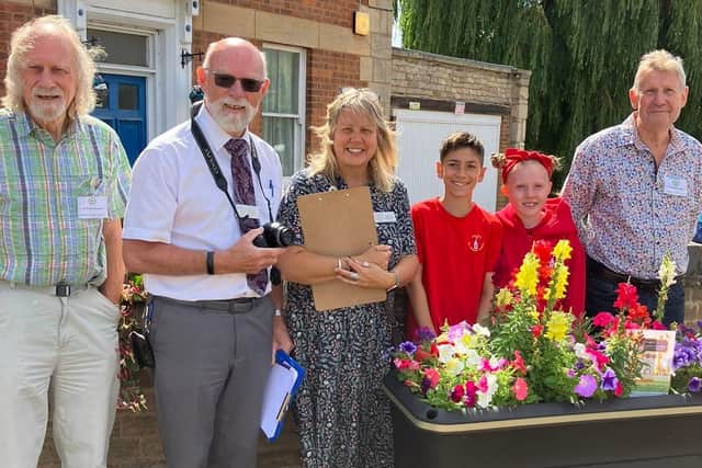 Weldon C of E pupils show the planter project to the judges and volunteers