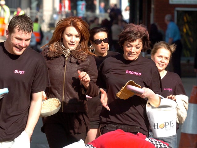 Wellingborough, Town Centre, shop workers and construction workers pancake race through the newly repaved Silver Street March 2011