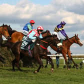 Corach Rambler (far side) jumps one of Aintree's famous fences, The Chair, on his way to victory in last year's Grand National.