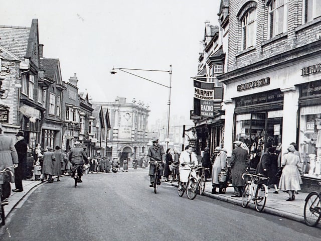 A post-war Rushden High Street with two-way traffic - mostly bikes