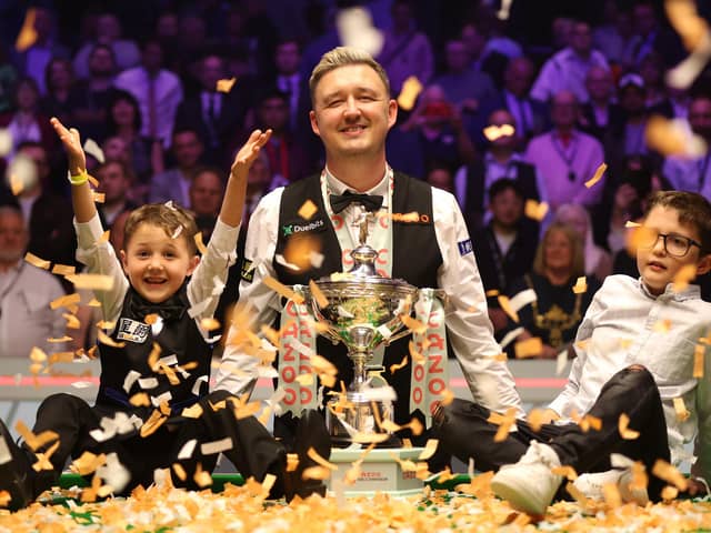 Kyren poses with his children on the table alongside confetti to celebrate his World Championship win.