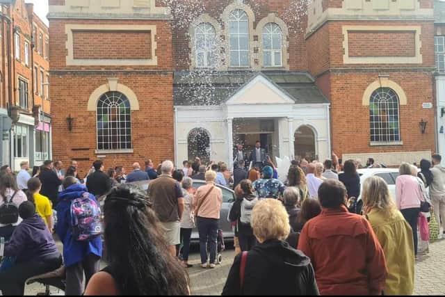 The grooms emerge on the steps of the Toller Church in Gold Street, Kettering watched by a crowd of well-wishers