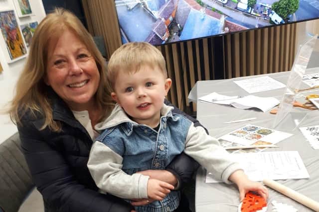 Three year old Rhys with Grandma Gill Bremner rolls out the clay