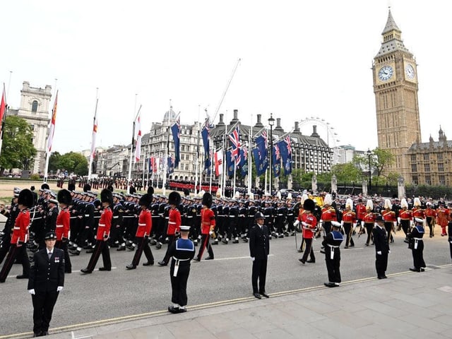 The coffin of Queen Elizabeth II with the Imperial State Crown resting on top, borne on the State Gun Carriage of the Royal Navy proceeds past the Houses of Parliament towards Westminster Abbey