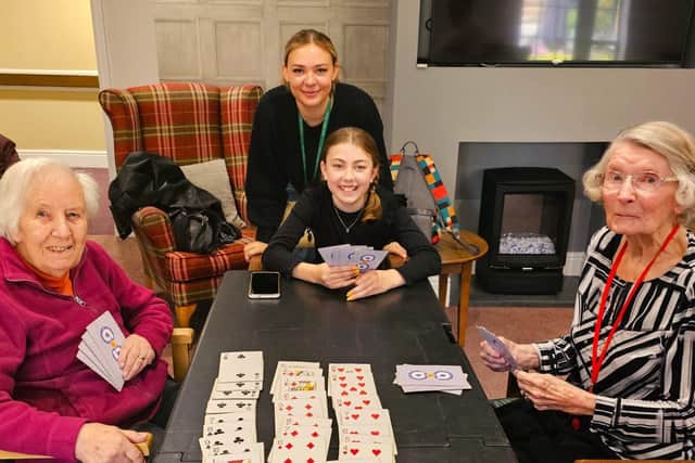 Residents with Stone Lodge School, teacher and pupil, enjoying a good old fashioned game of cards