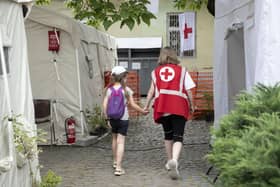 A Red Cross worker accompanies a child at the Red Cross Health Centre in Uzhhorod, eastern Ukraine