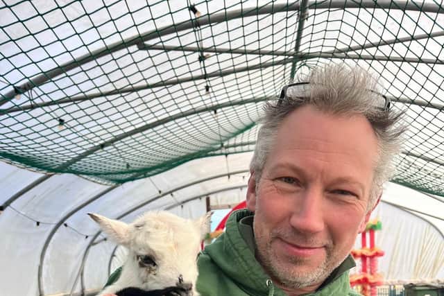 Mini Meadows Farm owner, Ben Barraclough, with a goat kid.