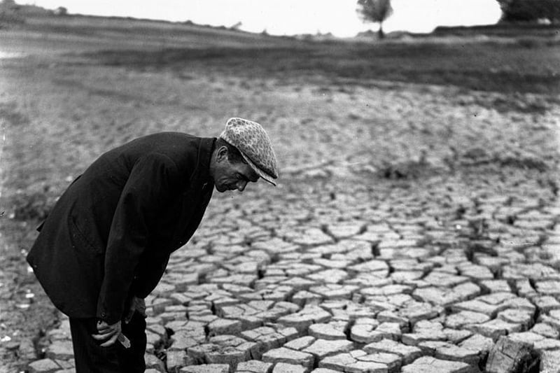 A man stands in the reservoir at Kettering surveying its sun-baked bottom, following the previous summer's drought. The reservoir is only one-fifth full.  Pictured 31st December 1934.