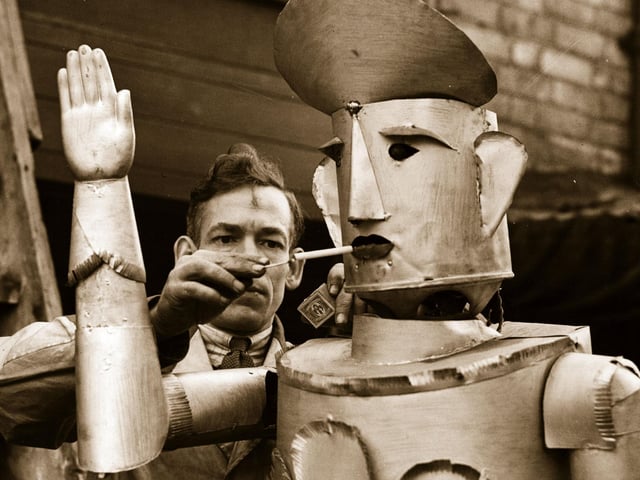 15th January 1939: Mr Charles Lawson, an electrical engineer of Kettering lights his robot's cigarette. (Photo by Fox Photos/Getty Images)