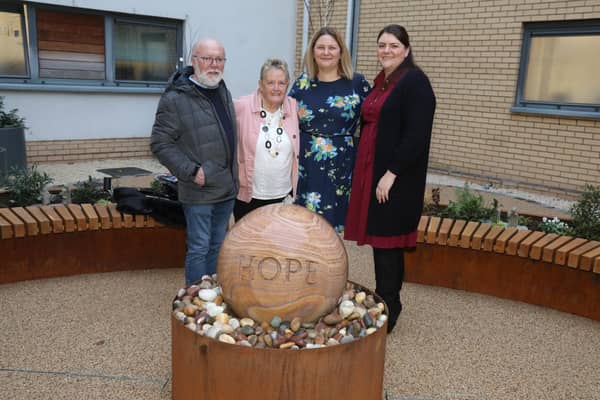 Glennis Hooper in pink jacket, with Marilyn Chapman's family with the water feature at Kettering General Hospital's Treatment Centre/National World