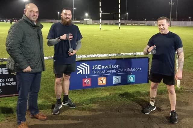 Nathan Hand and Alden Marshall from S&L Rugby Club presented with medals from the S&L Rugby Club president and the managing director of JS Davidson Ltd who sponsored the pair £1 each per kilometre during their month-long run last year.