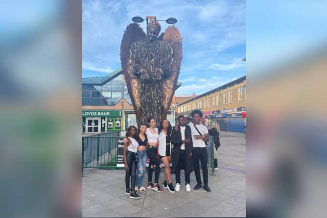 Members of the Hearts of Young People youth club next to the Knife Angel